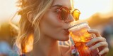 Close-up mujer joven en un festival, bebiendo alcohol en verano, chica con mojito de fresa al atardecer, recuerdo de verano en Ibiza