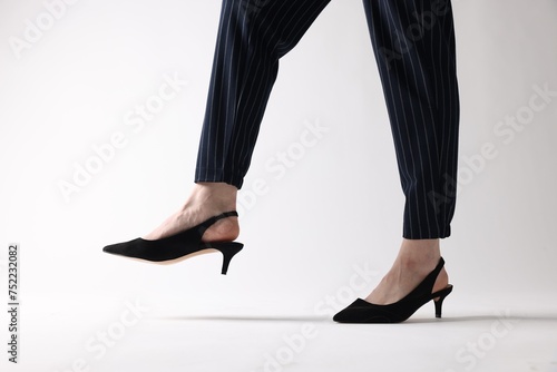 Businesswoman in black shoes on white background, closeup