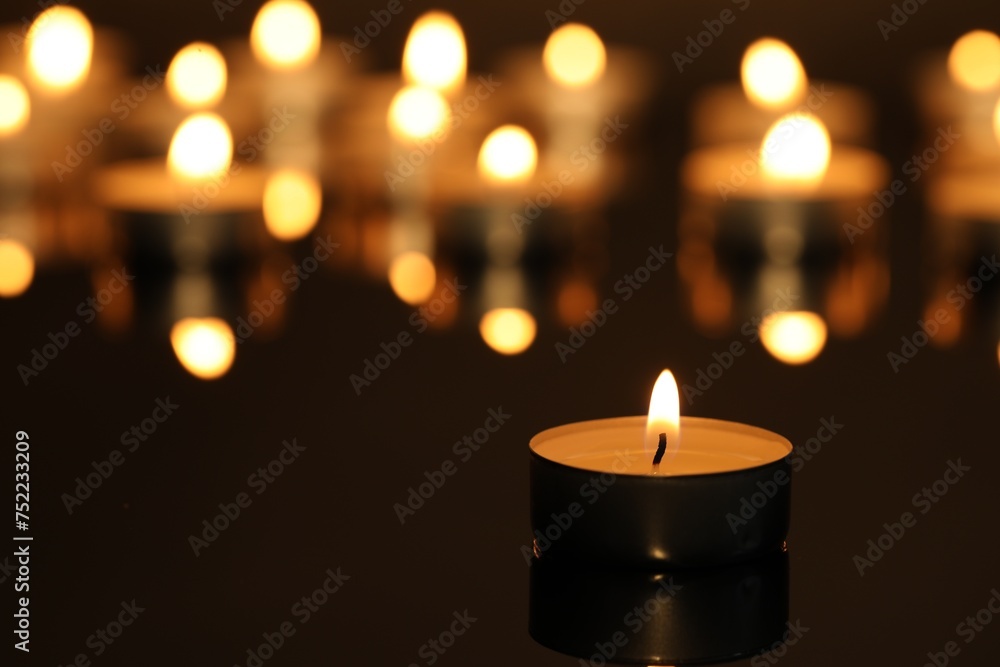 Burning candle on surface in darkness, closeup. Space for text Burning candle on surface in darkness, closeup. Space for text