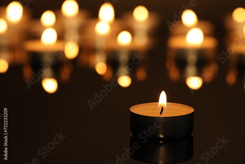 Canvastavla Burning candle on surface in darkness, closeup. Space for text