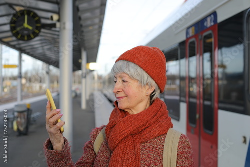 Senior woman using a mobile app to buy her train tickets