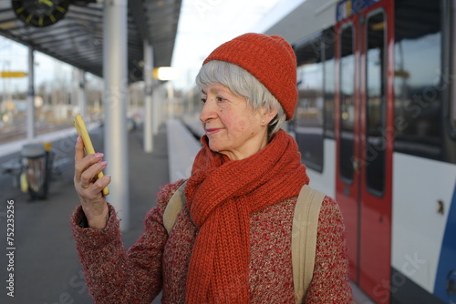 Senior woman using a mobile app to buy her train tickets 