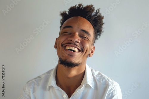 Portrait of a joyful young man in white shirt