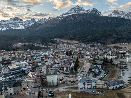 Aerial drone view of Andalo town with mountains background in winter. Snow covered Italian Dolomites at winter. Ski resort Paganella Andalo, Trentino-Alto Adige, Italy Italian Dolomites Pagnella.