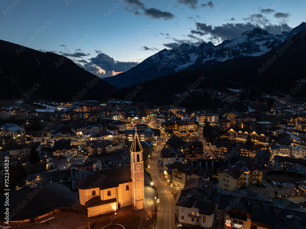 Aerial drone view of Andalo town at night with mountains background in winter. Snow covered Italian Dolomites at winter.Ski resort Paganella Andalo, Trentino-Alto Adige, ItalyItalian Dolomites