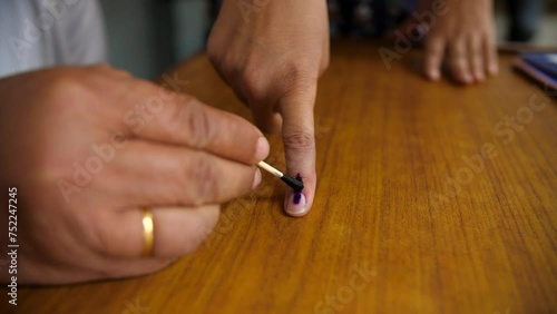 An electoral officer applying electoral stain ink on the index finger - general elections. Electoral ink used during polls in India - assembly elections  right to vote  indelible ink  electoral sta... photo