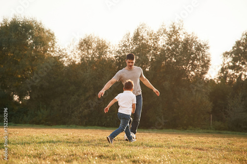 Conception of soccer game. Father and little son are playing and having fun outdoors