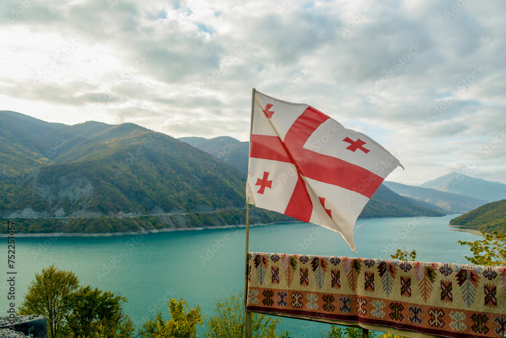 Georgia flag on a background of mountain landscape and lake