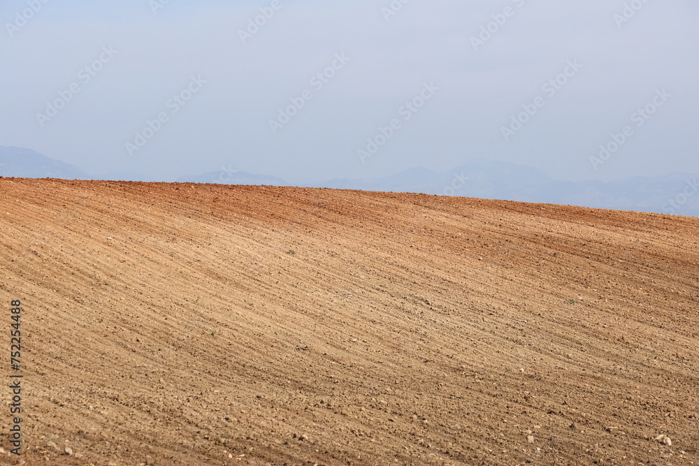 Fototapeta premium Agricultural field ploughed in spring. Arable land ready for the next cultivation season