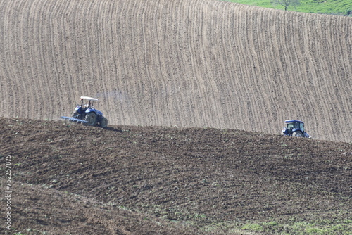 farmers plouging the field in spring photo