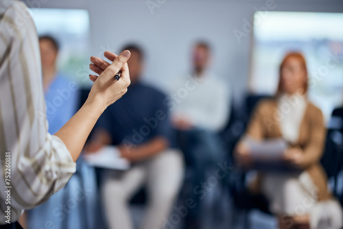 Focus on the female hand, giving a speech to her employees.