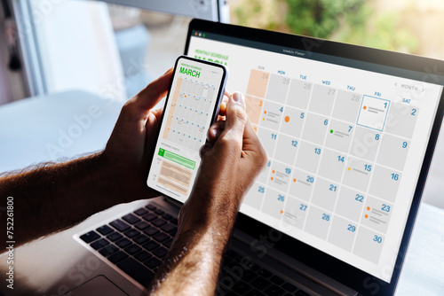 Man looking at calendar on phone and laptop, early in the morning for planning the day. Digital schedule concept. photo