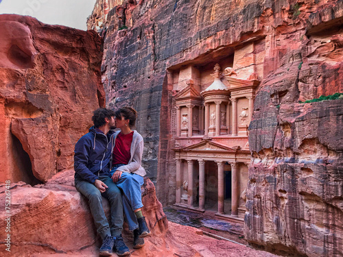 couple kissing with the facade of Petra in the background looking at the lost city. Love in Petra. one of the new seven wonders of the world.