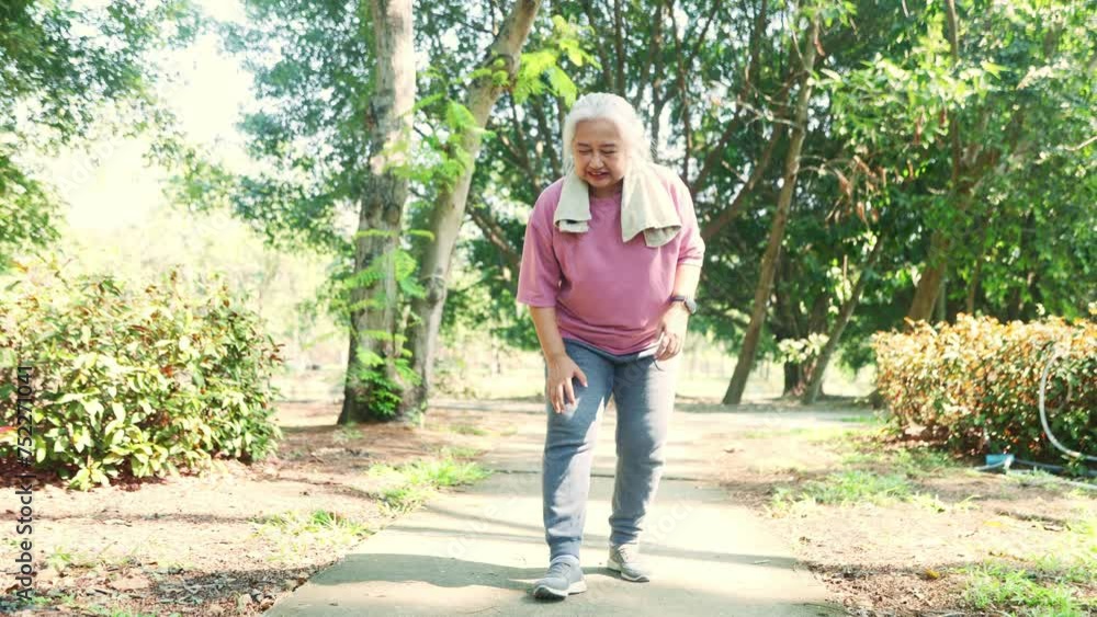 Senior woman gray hair walking and jogging in the park had sudden knee pain bone joint pain osteoarthritis and had to stop running to relieve the symptoms with gentle massage. Senior woman gray hair walking and jogging in the park had sudden knee pain bone joint pain osteoarthritis and had to stop running to relieve the symptoms with gentle massage.