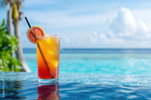 Tropical Tequila sunrise cocktail , freshness beverage fruits, orange and berries cocktail near swimming pool. Close up.