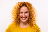 Close up portrait of happy ginger woman with freckles and curly hair.