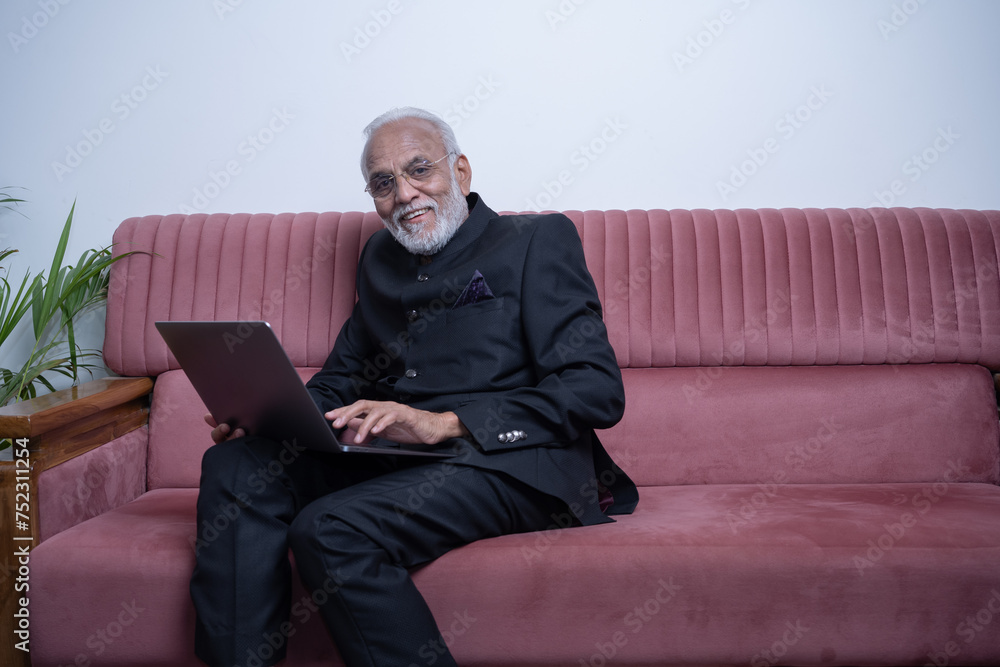 Portrait of mature Indian or Latin business man ceo trader using laptop computer, typing, working from home Portrait of mature Indian or Latin business man ceo trader using laptop computer, typing, working from home