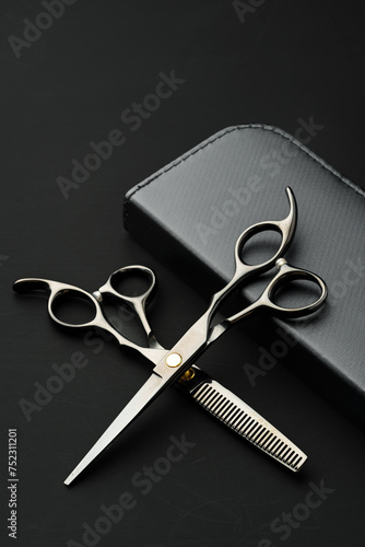 Hairdressing scissors with case on a black background