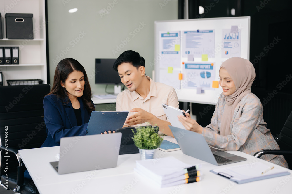 Group of young business people discussing business plan at modern startup in creative business discussing work modern office building. Group of young business people discussing business plan at modern startup in creative business discussing work modern office building.