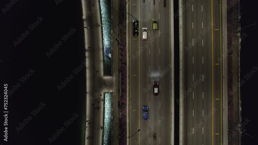 Road above water from the bird's eye view at night with boat under the bridge Road above water from the bird's eye view at night with boat under the bridge
