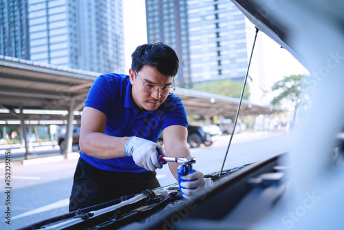  automobile car concept. Asian auto mechanic in blue uniform works on car engine Repair and customer service Working on engines in the garage. 
