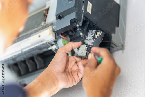 Technician checking thermistor, Repairman fixing air conditioning system, Technician service for repair and maintenance of air conditioners photo