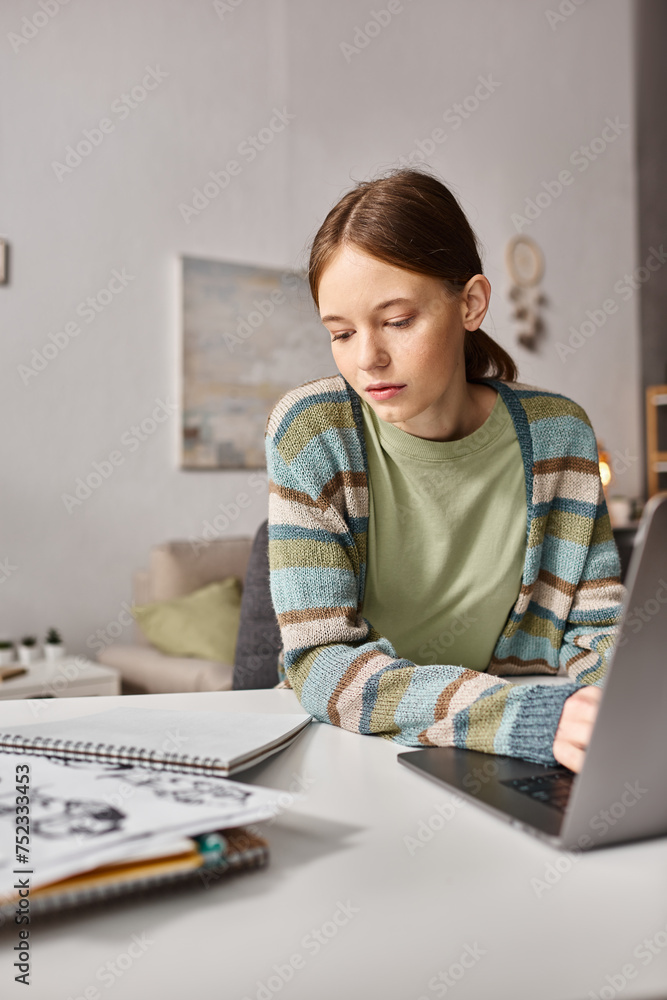 Teen girl engaged in e-learning with her notebook and laptop at a cozy home setting, digital age Teen girl engaged in e-learning with her notebook and laptop at a cozy home setting, digital age