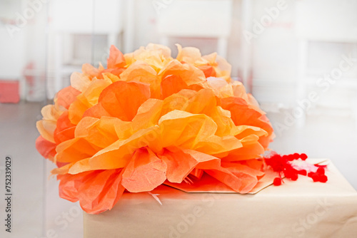 artificial orange flower made of corrugated paper. Gift wrap © Nataliia Makarovska