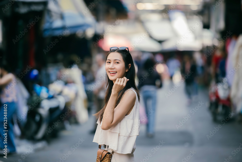 Portrait of young beautiful Asian tourist exploring the local town.