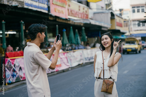 Young happy Asian couple tourist backpackers enjoy traveling in the local market.