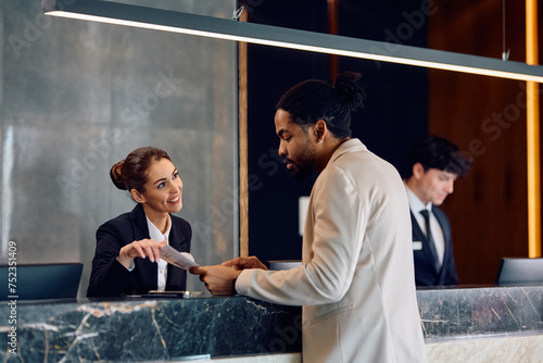 Canvastavla Happy receptionist assisting black male guest who is checking in at hotel
