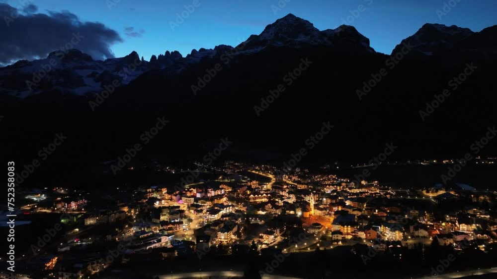 Aerial drone view of Andalo town at night with mountains background in winter. Snow covered Italian Dolomites at winter.Ski resort Paganella Andalo, Trentino-Alto Adige, ItalyItalian Dolomites Aerial drone view of Andalo town at night with mountains background in winter. Snow covered Italian Dolomites at winter.Ski resort Paganella Andalo, Trentino-Alto Adige, ItalyItalian Dolomites