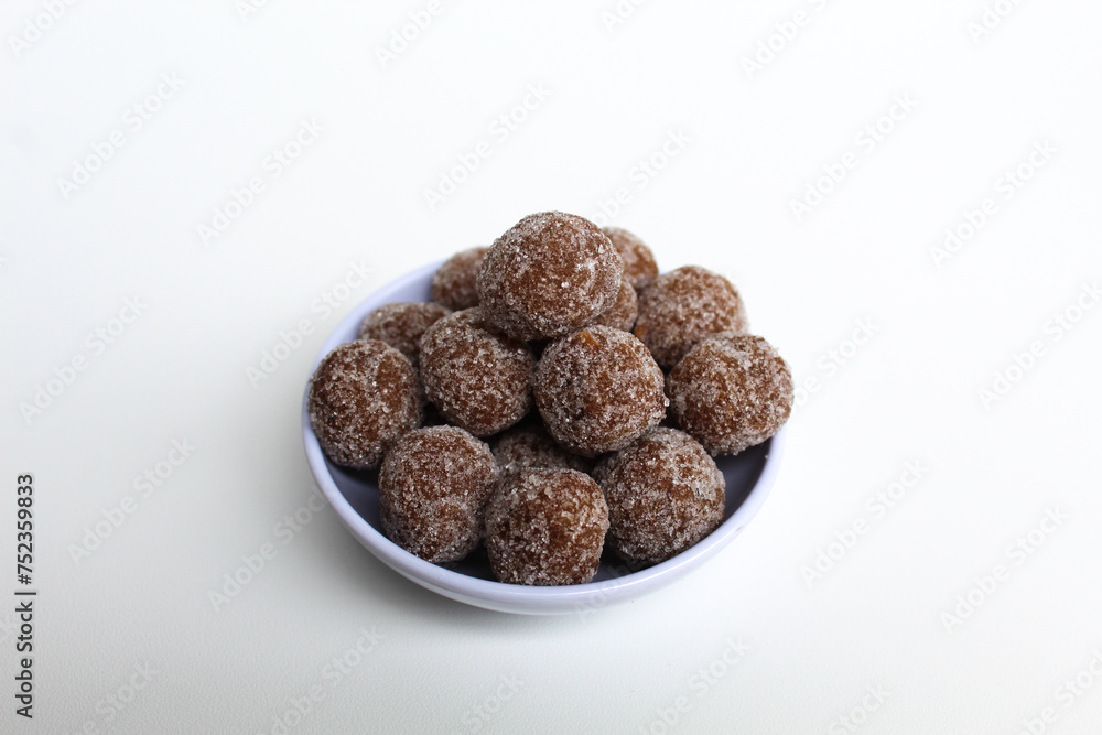 Tamarind candy balls in white bowl. Isolated on white background Tamarind candy balls in white bowl. Isolated on white background