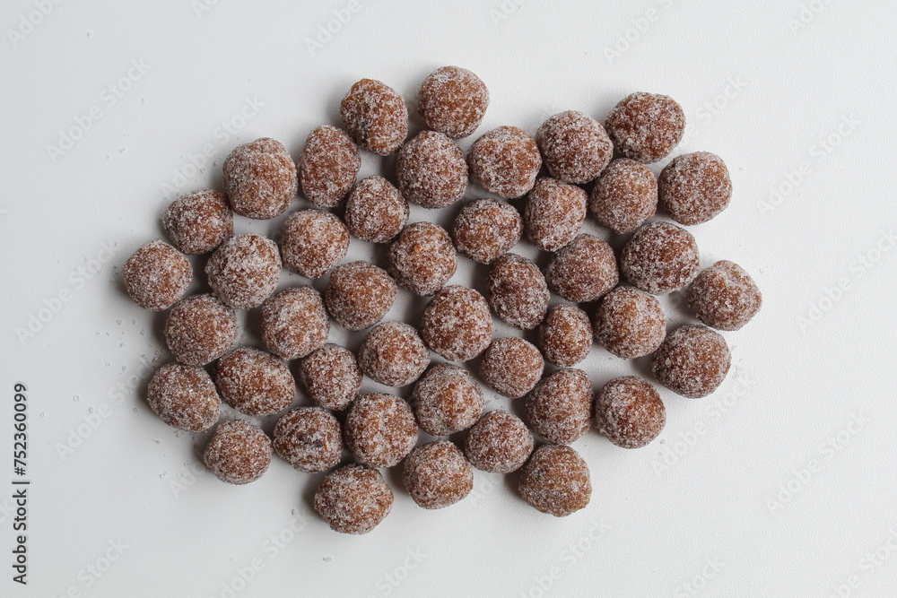 Tamarind candy, small ball shaped. On white background, flat lay or top view Tamarind candy, small ball shaped. On white background, flat lay or top view