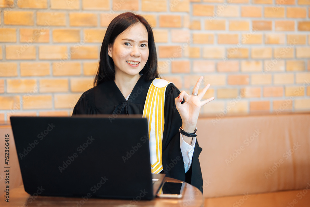 Asian female lawyer gives thumbs up OK Using a laptop to type in a law office from police investigations and judgments from judges to prosecute clients against defendants who have committed crimes. Asian female lawyer gives thumbs up OK Using a laptop to type in a law office from police investigations and judgments from judges to prosecute clients against defendants who have committed crimes.