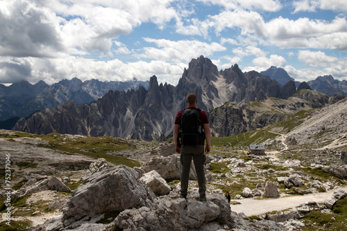 Stunning view of a tourist enjoying the view of the Tre Cime Di Lavaredo, Dolomites, Italy.