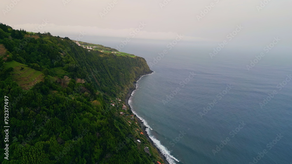 Panoramic sea shore landscape on rainy cloudy day. Aerial dark ocean washing 