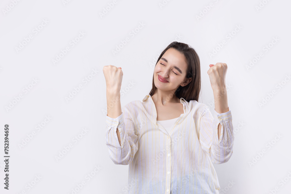 Happy young caucasian female wearing a white shirt clenched fist up for joy. Success and happiness of the work. Successful person, victory! Happy young caucasian female wearing a white shirt clenched fist up for joy. Success and happiness of the work. Successful person, victory!