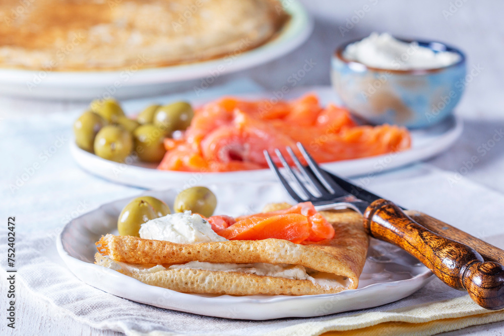 Pancakes with gravlax, cottage cheese and olives. A traditional dish for Maslenitsa or Carnival.