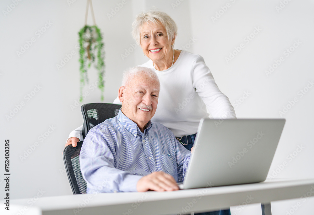 senior couple using a laptop while sitting at the office senior couple using a laptop while sitting at the office