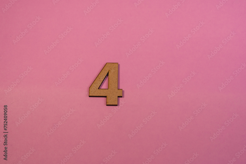 Number 4 in wood on a pink background Number 4 in wood on a pink background