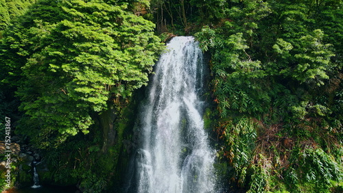 Powerful waterfall falling tropical forest. Drone shot of raging water flowing