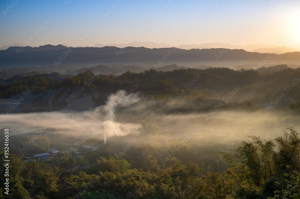 In the morning, smoke curls up from the valley and the bamboo forest is green. The Erliao tribe in Zuozhen enjoys the sunrise landscape, Tainan City, Taiwan.