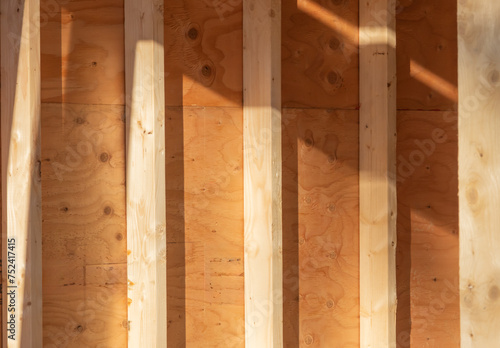 Detail from the inside of an interior wood stud wall showing the studs and plywood sheathing
