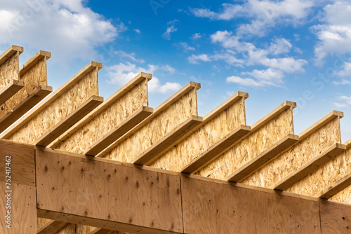 Schilderij op canvas Engineered wood joists or rafters forming the roof of a house under construction