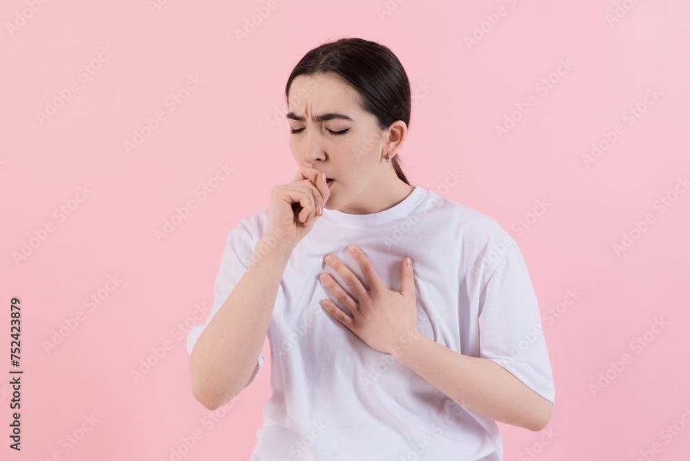 Attractive Caucasian young brunette woman in casual clothes suffers due to cough, cold isolated on pink studio background. Medicine, health, illness. Attractive Caucasian young brunette woman in casual clothes suffers due to cough, cold isolated on pink studio background. Medicine, health, illness.