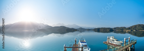 In the early morning sunshine, the dock, lake and mountains are all in sight. Sun Moon Lake is one of Taiwan's famous tourist attractions. Nantou county. photo