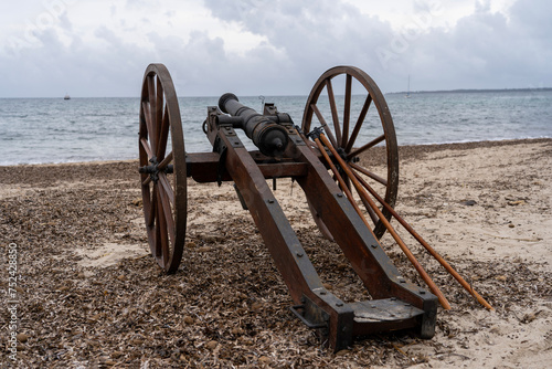 Historical reenactment of events. Cannon from the time of Napoleon Bonaparte on the beach against the backdrop of the sea and clouds.