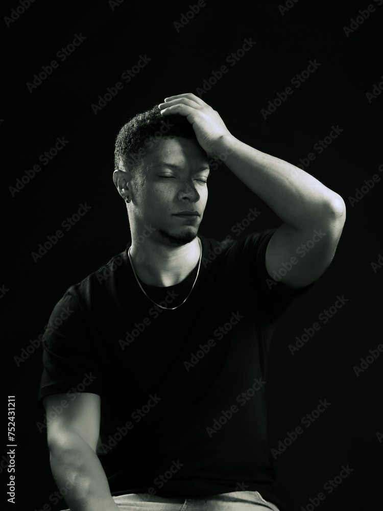 Young man holding his head out of regret or pain. black and white photo