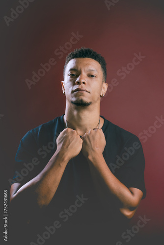 Obraz na płótnie Portrait of serious looking young African American man holding on to neck chain w salonie